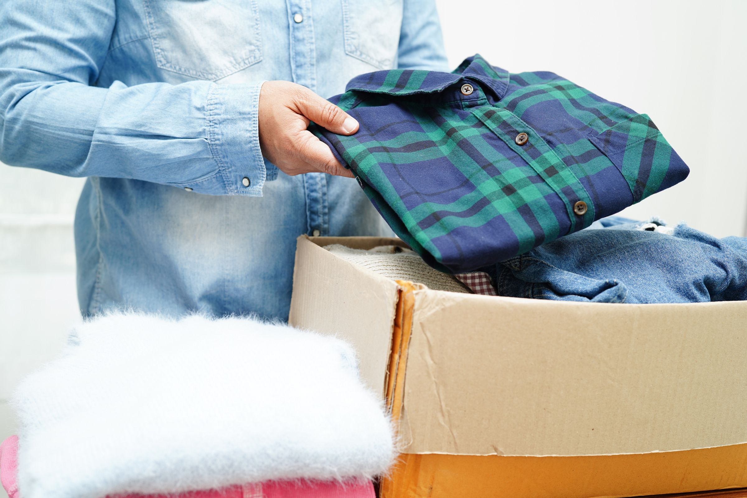 Clothes donations in cardboard box for volunteer.