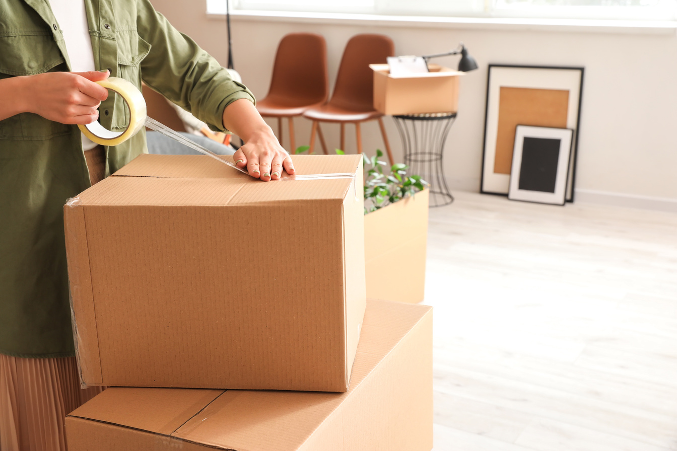 Woman Packing Moving Box at Home